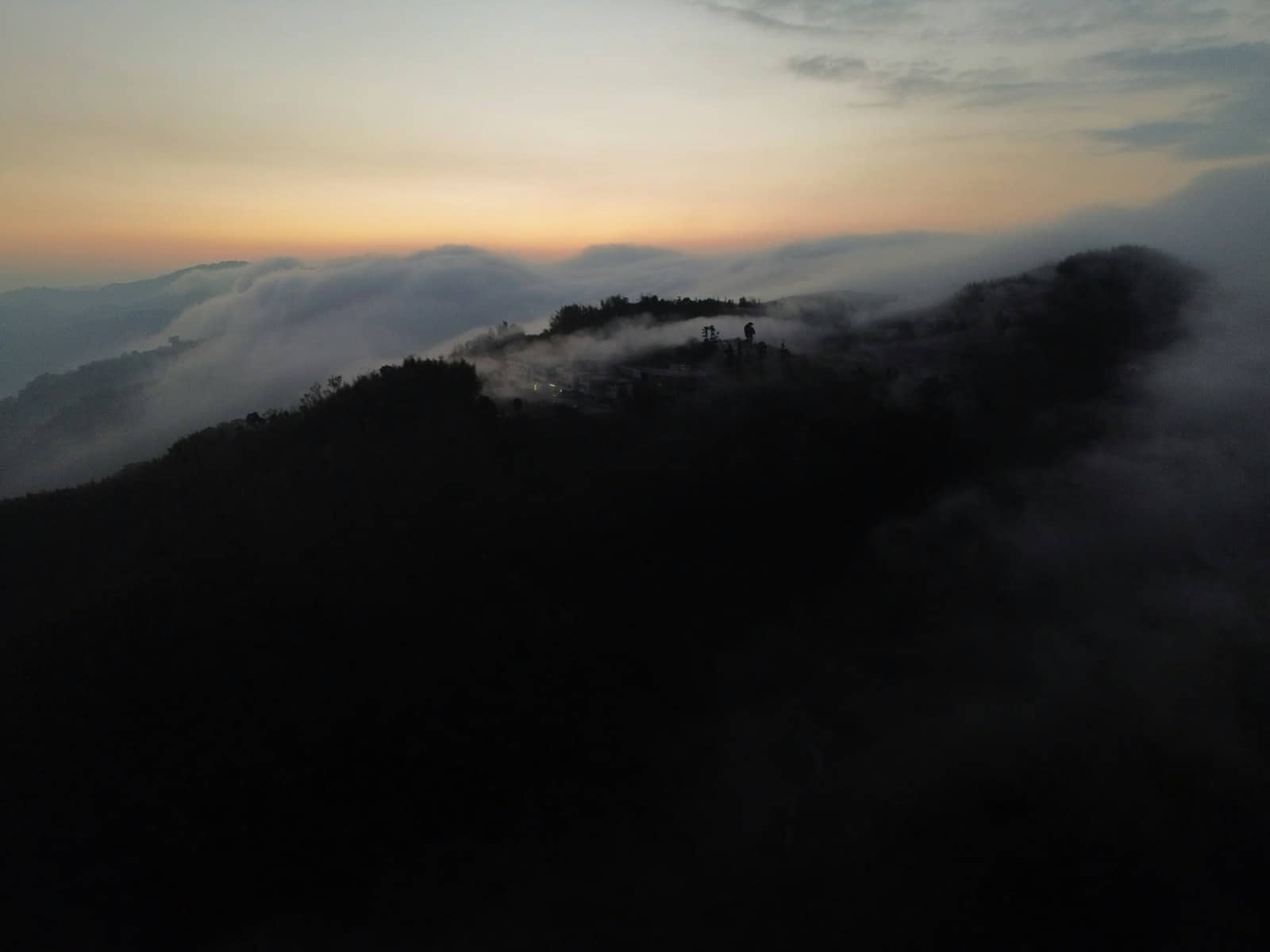 Drone shot of misty hills at sunrise